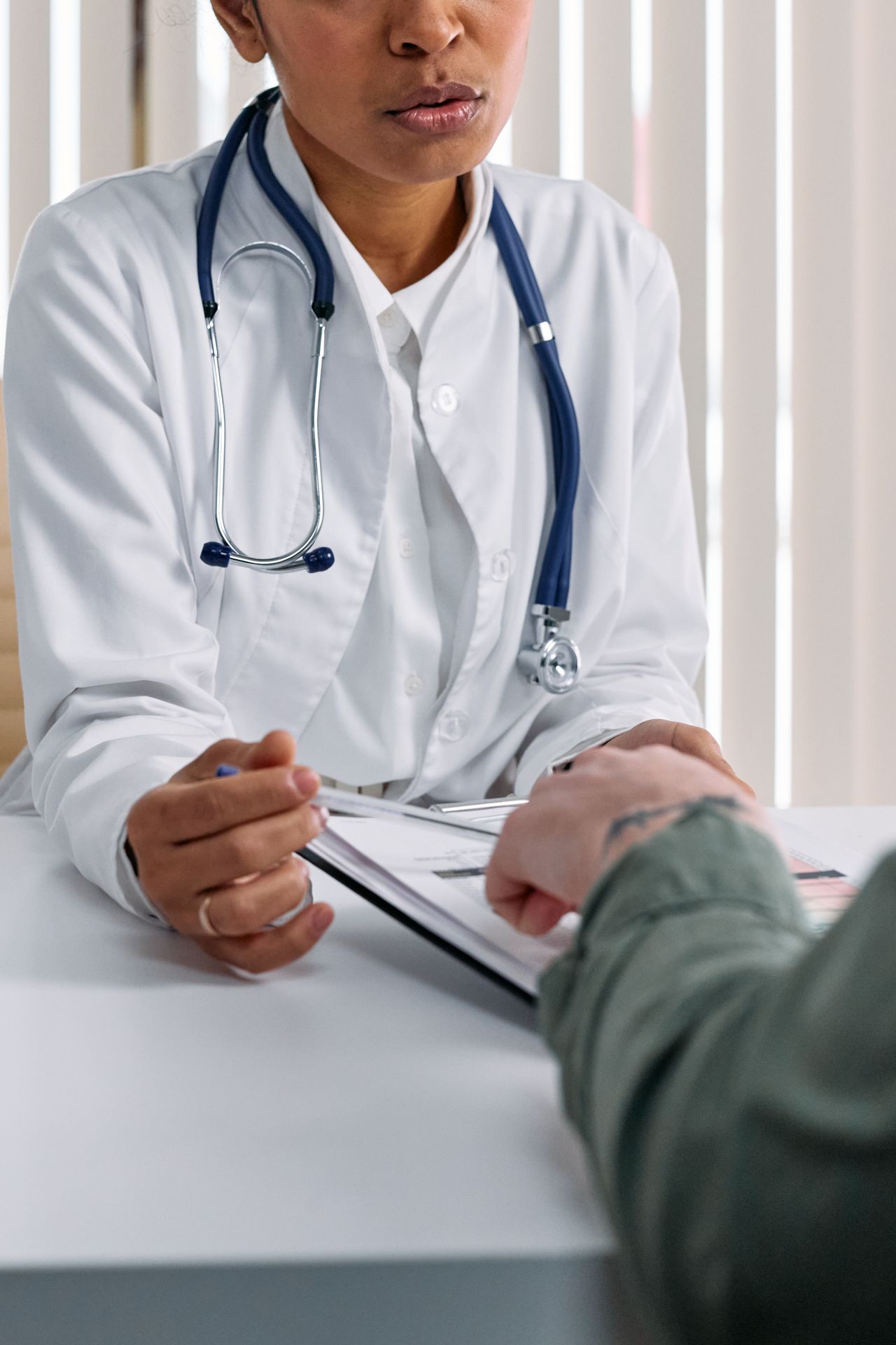 Physician reviewing case details with a patient at a desk