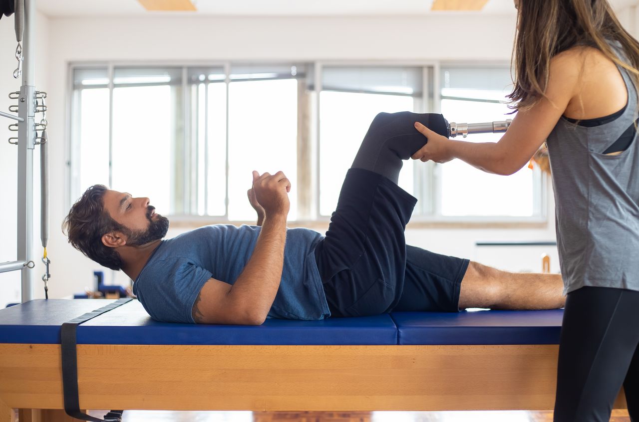 Physical therapist rehabilitating a patient with a prosthetic limb